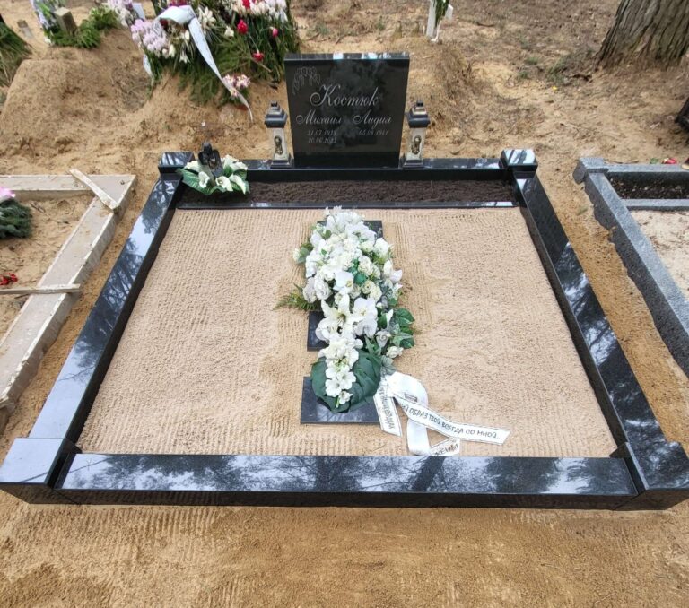 Pärnamäe kalmistu OÜ meistrite valmistatud poleeritud graniidist hauapiire koos ilusa lillepärjaga.