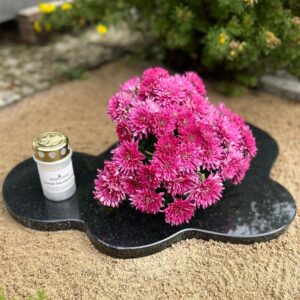 Mustast graniidist pilvekujuline lille- ja küünlaalus koos lilledega