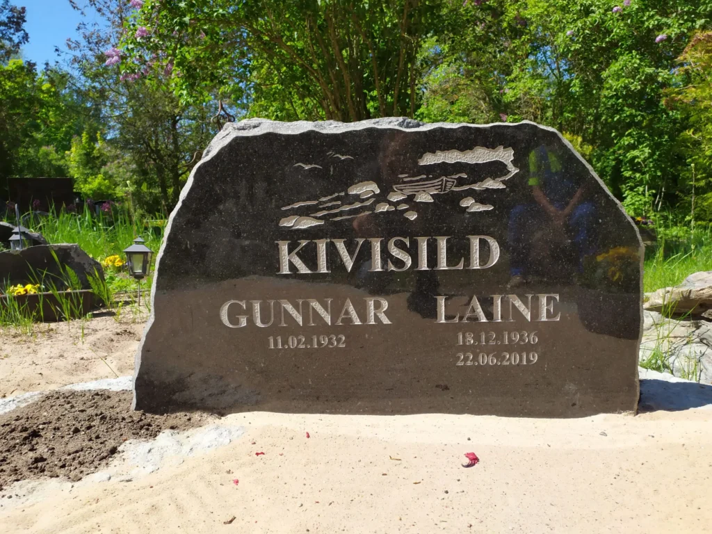 meie valmistatud klombitud servadega mustast graniidist hauakivi hauaplatsil